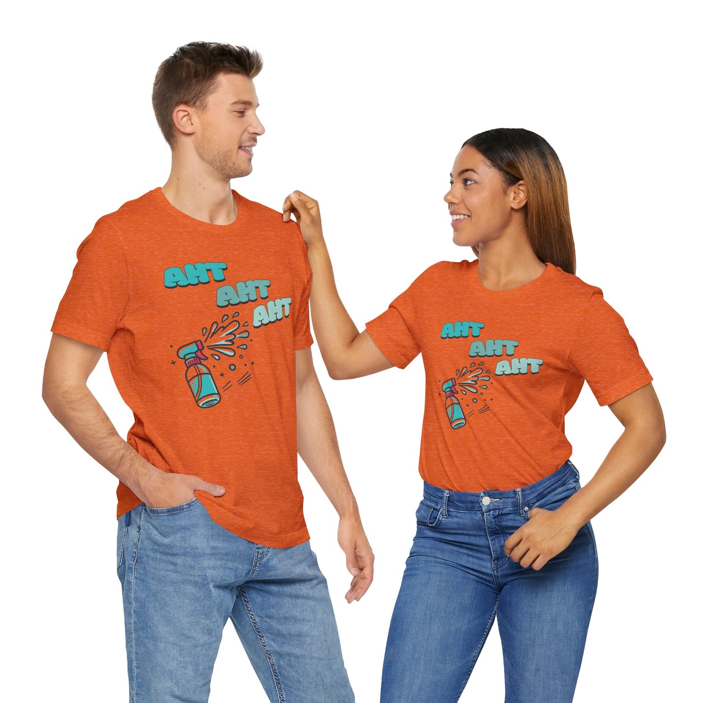 a couple wearing a spray bottle shooting three squirts of water, each squirt accompanied by the playful text 'Aht Aht Aht.' The design is printed on a heather orange T-shirt, adding a humorous and cheeky vibe, perfect for warding off unwanted behavior with a lighthearted message.