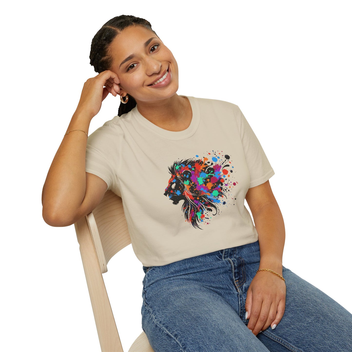 a woman wearing a sand colored tshirt background featuring a vibrant ink splatter forming the side profile of a lion's head, showcasing bold colors and dynamic artistic detail.