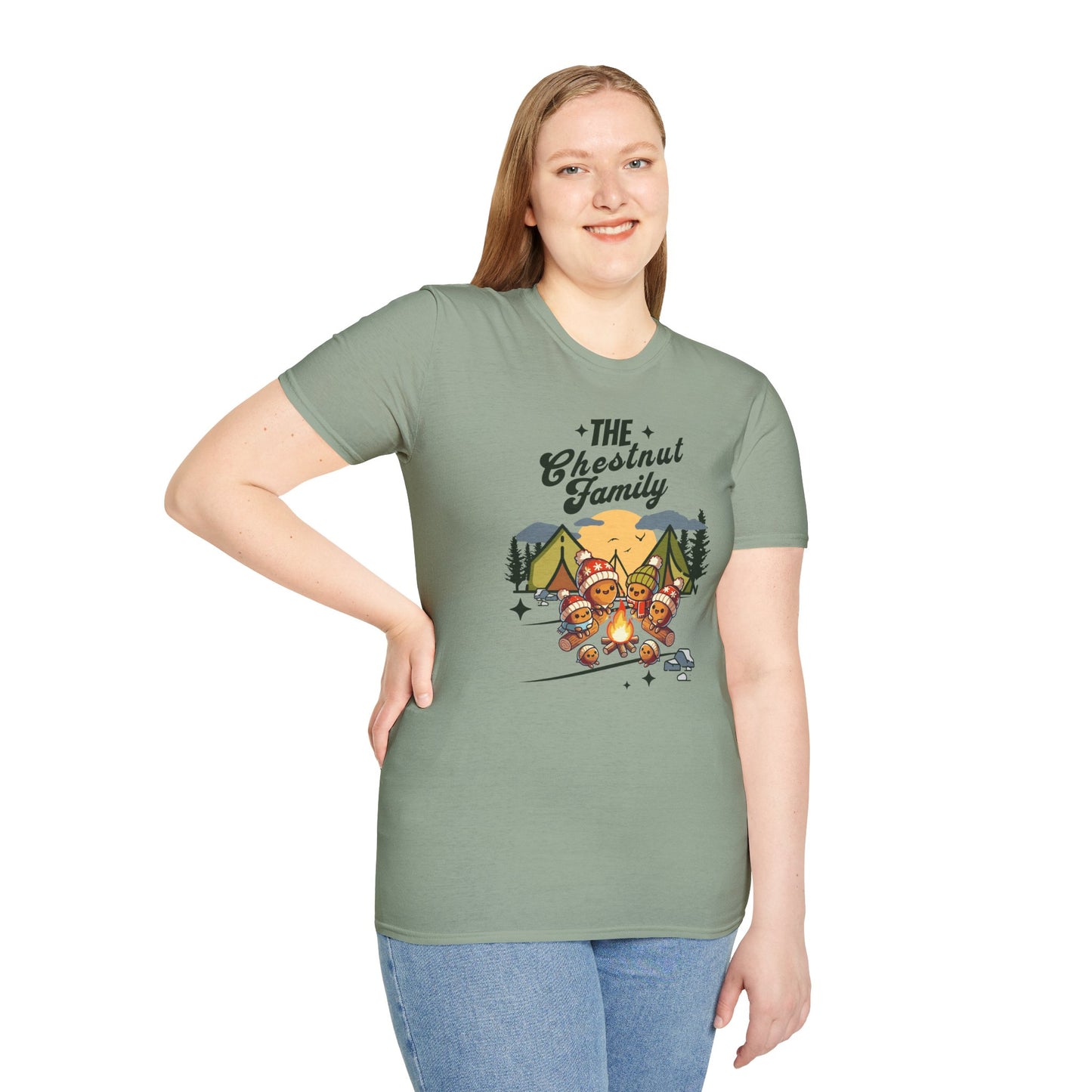 a woman wearing a sage colored t-shirt with an image of a cartoon family of chestnuts sitting by an open fire at a campsite