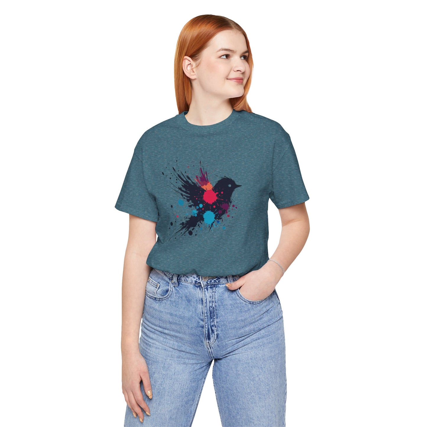 a woman wearing a deep heather teal color t-shirt with an image of blue red and orange paint splatter bird