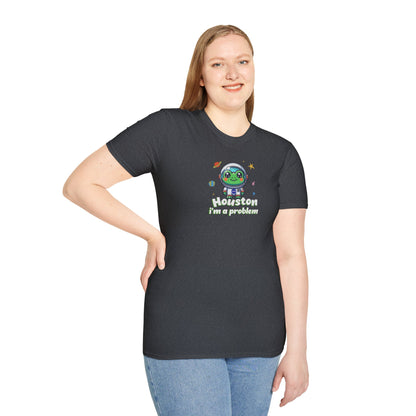 a woman wearing a dark heather grey colored t-shirt with graphic of a cute astronaut frog in a spacesuit, ready for an interstellar adventure. The design showcases the frog as a space cadet, radiating charm and joy, perfect for spreading smiles across the galaxy