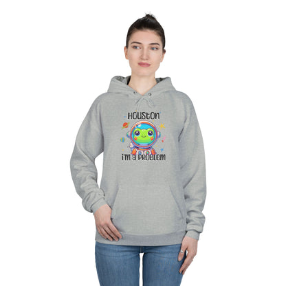 a woman wearing a steel colored hoodie with graphic of a cute astronaut frog in a spacesuit, ready for an interstellar adventure. The design showcases the frog as a space cadet, radiating charm and joy, perfect for spreading smiles across the galaxy