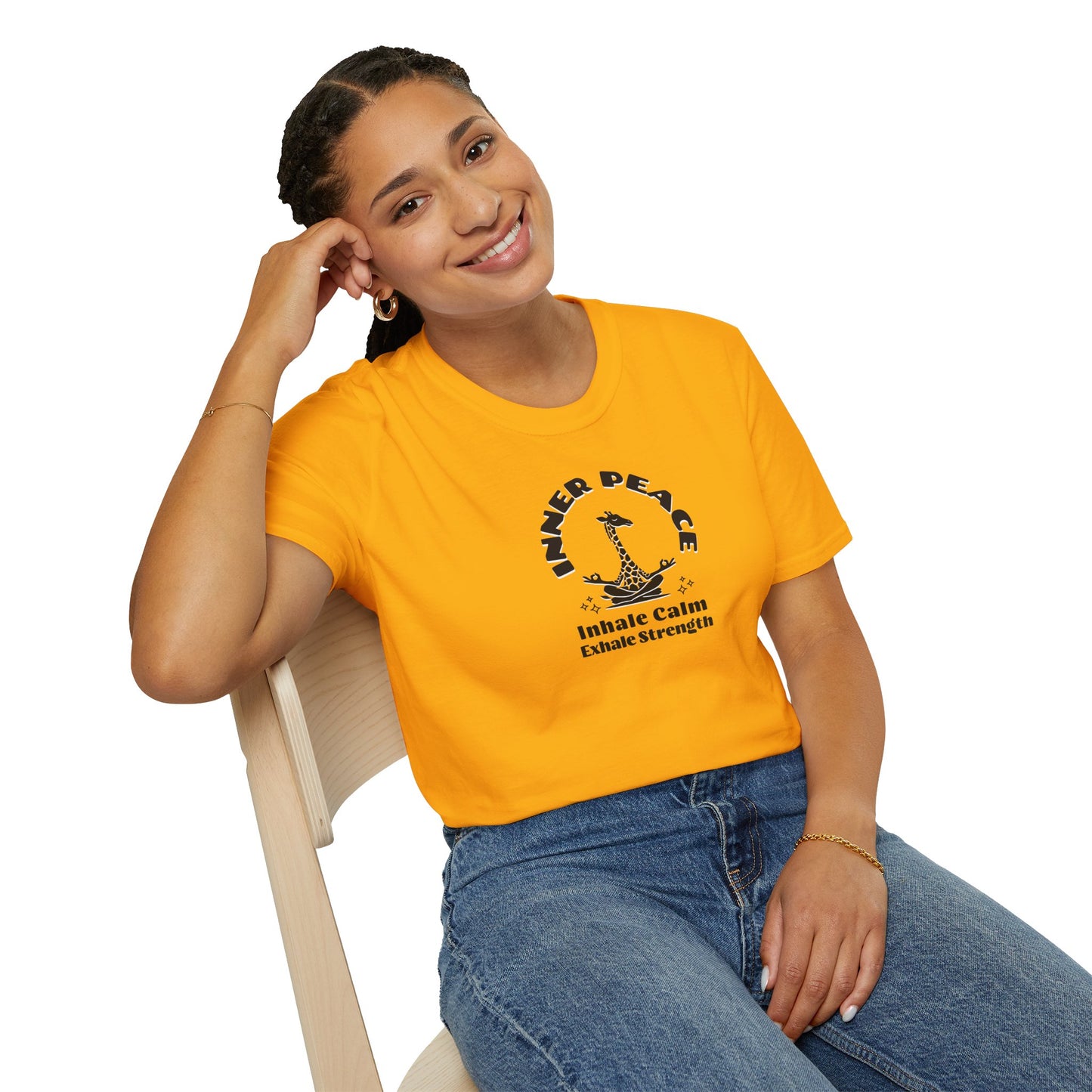  a woman wearing a gold  colored t-shirt with image of a giraffe in a zen position with the text surrounding image, inner peace, inhale clam exhale strengths.