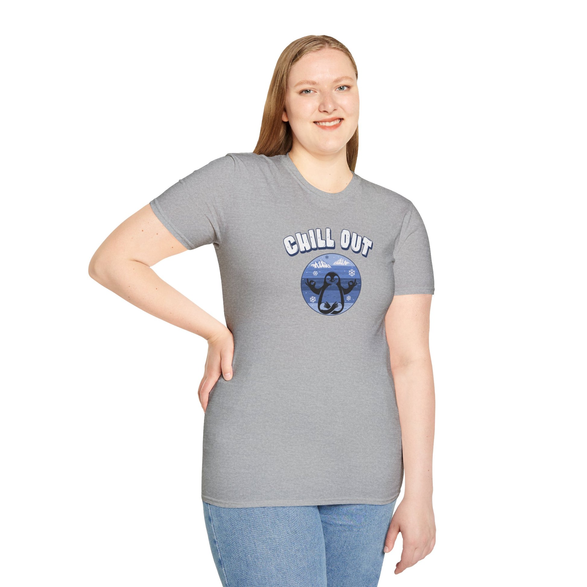 a woman wearing a a sport grey t-shirt featuring a relaxed penguin in a calm yoga pose, set against serene blue waters, snowy peaks, and gentle snowflakes. Perfect for promoting relaxation and cozy, laid-back vibes.