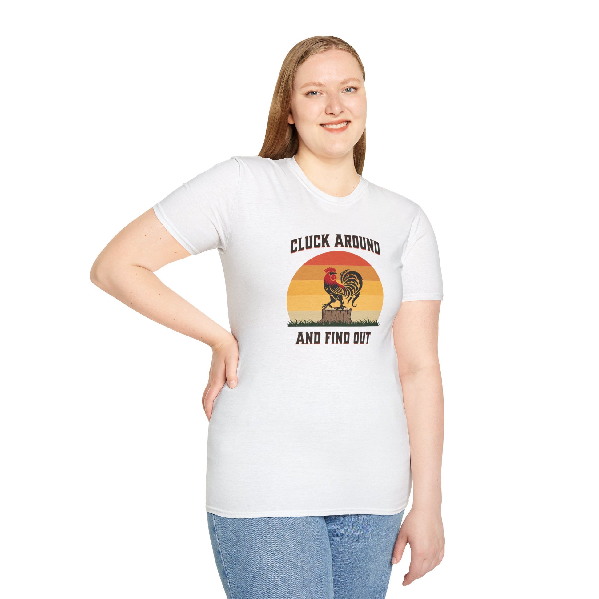 a woman wearing a white t-shirt featuring a red and black rooster standing on a brown tree stump on green grass, set against a retro red-to-orange sunset background with the text 'Cluck Around and Find Out'.