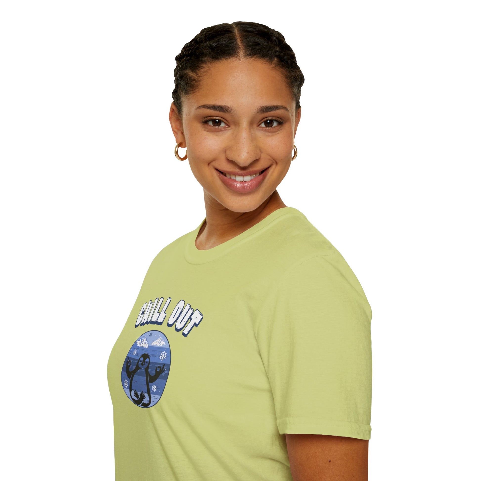 a woman wearing a pistachio color t-shirt featuring a relaxed penguin in a calm yoga pose, set against serene blue waters, snowy peaks, and gentle snowflakes. Perfect for promoting relaxation and cozy, laid-back vibes.