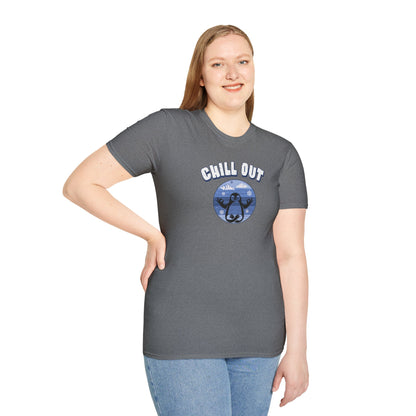 a woman wearing a graphite heather colored t-shirt featuring a relaxed penguin in a calm yoga pose, set against serene blue waters, snowy peaks, and gentle snowflakes. Perfect for promoting relaxation and cozy, laid-back vibes.